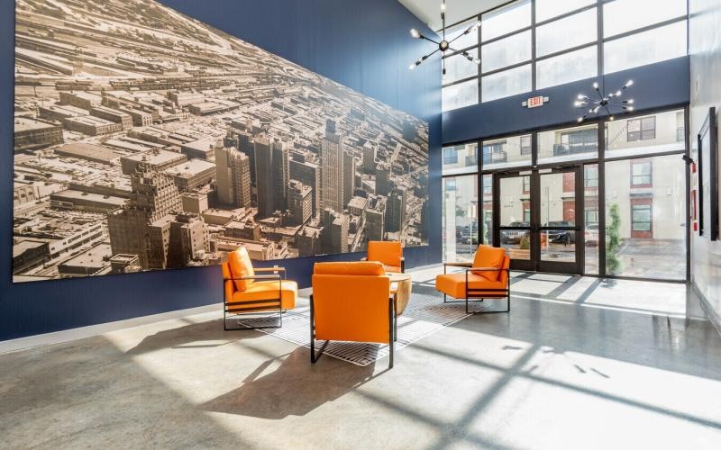 a group of orange chairs in front of a large mural