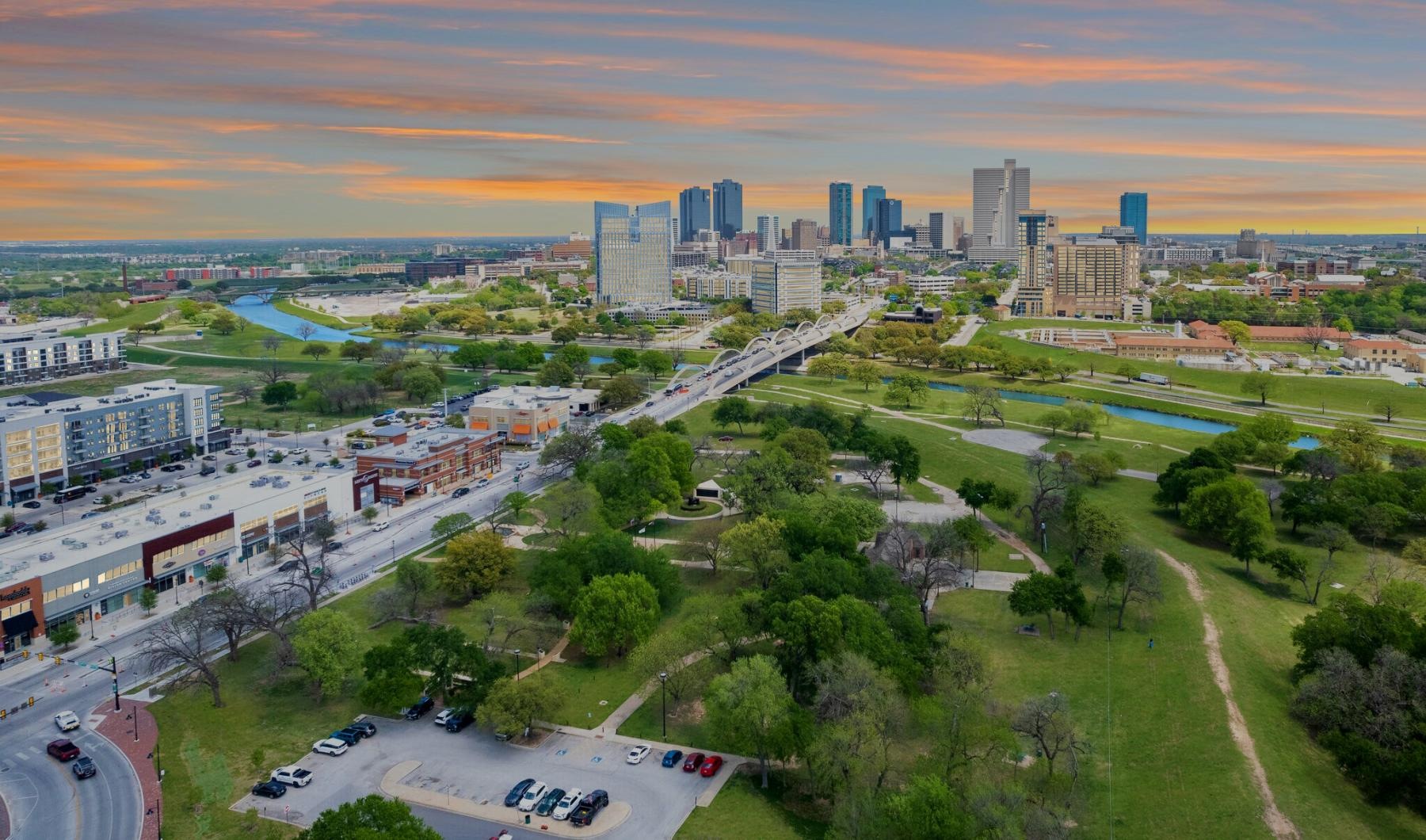 a city landscape with a park and a road