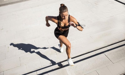 woman exercises running outside up stairs