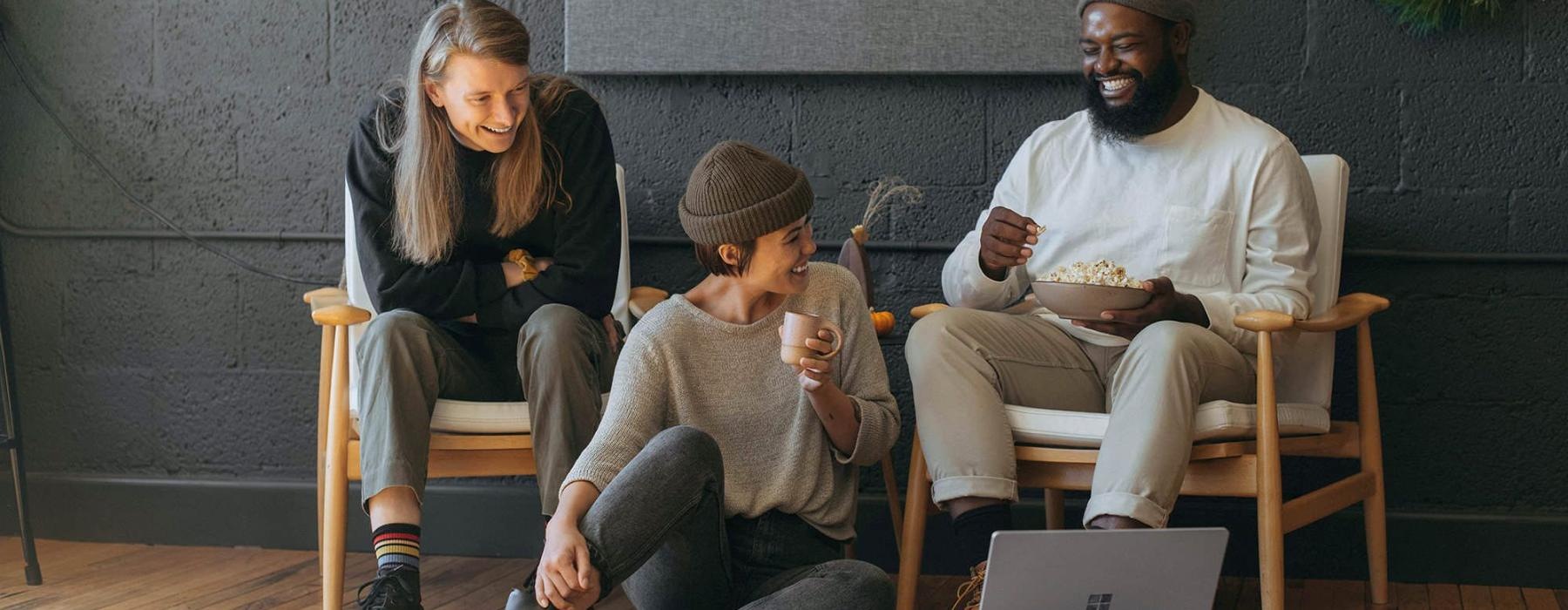 friends sit together around an open laptop